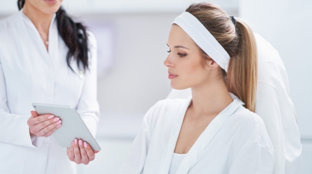 An Aesthetician consulting a patient about natural anti-aging and laser rejuvenation at Reveal Clinics Riyadh.