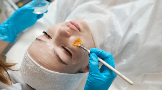 Dermatologist applying advanced chemical peel treatment on face